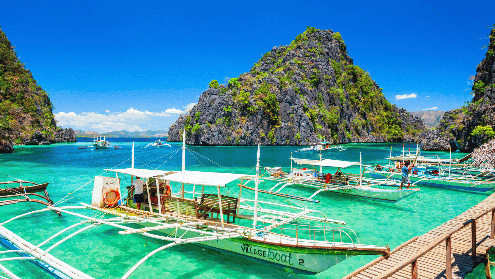Tropical island boats docked in clear blue water, perfect for unique shore excursions from Singapore cruises.